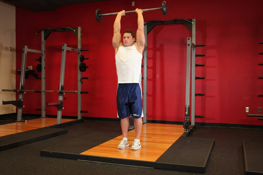 Standing Overhead Barbell Triceps Extension — end position